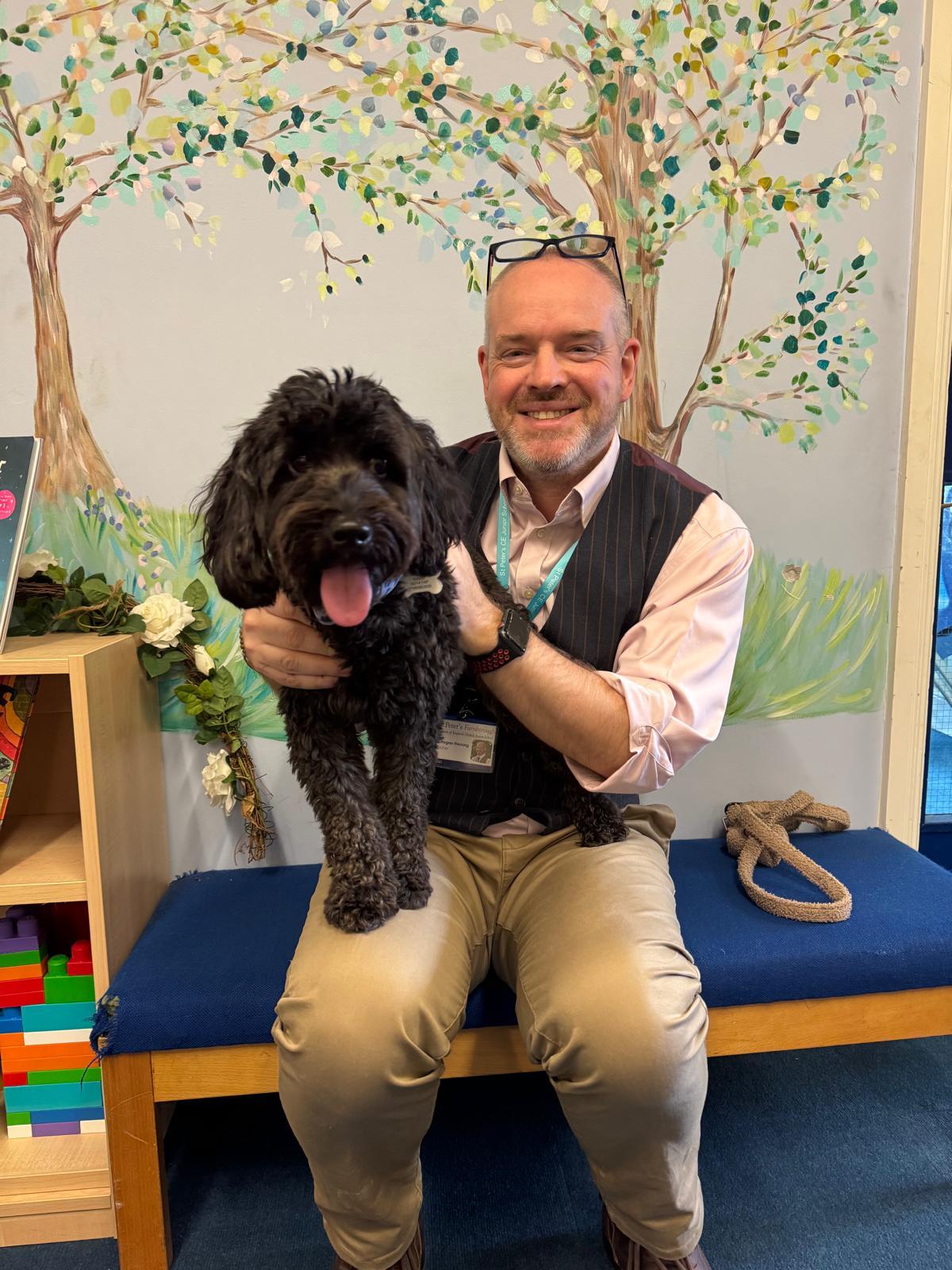 Headteacher seated with school dog